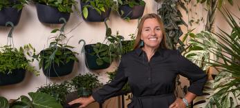 Chelsea Thomas poses amid dozens of green plants at Plantae in Flagstaff. By John Burcham