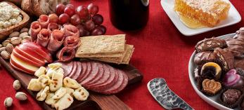 Assorted food gifts, including nuts, chocolates, olives, cheese and salami.