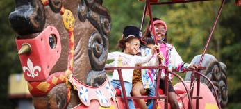 Four children with big smiles ride the giant rocking horse at the arizona Renaissance Fair.