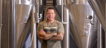 John Peasley stands near large vats at the Grand Canyon Brewing Co.