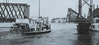 The gas-powered riverboat Aztec passes through a movable bridge at Yuma in 1902. The Aztec moved cargo on the Colorado River between Yuma and Needles, California, until 1905, when a severe sandstorm caused it to wreck a few miles downstream from Needles. | THE HUNTINGTON LIBRARY