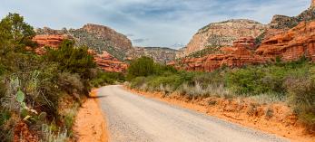 Well-maintained Forest Road 525 curves toward the sandstone buttes of Red Rock Country. By Derek von Briesen