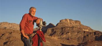 Jerry Jacka poses with a 4x5 camera mounted on a tripod in the Arizona desert. | COURTESY OF THE JACKA FAMILY