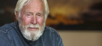 Portrait of David Muench leaning on a leather chair arm. | PAUL MARKOW  ABOVE JOEL GRIMES