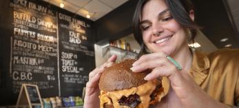 A woman prepares to take a bite of a big cheeseburger at JoeJoeBob's in Flagstaff. By Dawn Kish