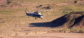A Sikorsky helicopter lifts the remains of Chindesaurus bryansmalli, a dinosaur popularly known as “Gertie,” from the layered landscape  of Petrified Forest National Park on June 6, 1985. The fossilized dinosaur was discovered near what now is called Hózhó Point. | Jeff Kida