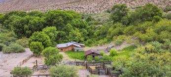 Immediately surrounded by green vegetation, Tassi Ranch sits on a rugged and remote stretch of northwest Arizona. By John Burhcam