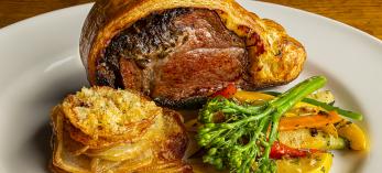 Beef Wellington with potato slices and vegetables fill a plate at Le Rendez-vous. By Steven Meckler