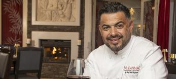Eddie Guzman poses at Julianna's with a signature steak dish and a glass of red wine. By Paul Markow