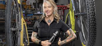 Jenna Majchrzak between bicycles and among tools at Transit Cycles, her bike shop. By Steven Meckler