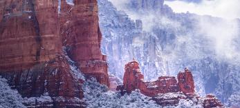 Fog and snow-covered foliage combine to form a wintry scene amid the sandstone buttes of Red Rock Country. The formations seen in the foreground are part of Snoopy Rock, named for its resemblance to the Peanuts character. | Larry Lindahl