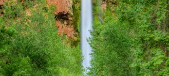 Plunging nearly 200 feet into a turquoise pool, Mooney Falls is per-haps the most dramatic cascade in the village of Supai, at the far western edge of the Grand Canyon. | Suzanne Mathia