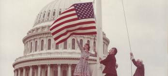 On June 14, 1976, Carolyn Hartmann (left) and Associate Editor Wes Holden (center) flew an American “flag rug” over the U.S. Capitol.