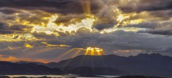 Rays of sunlight burst through dark and gloomy storm clouds at Parker Canyon. | Claire Curran