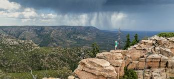 Writer Tyler Williams surveys a significant  rainstorm from the Mogollon Rim, east of Baker Butte. There, the Rim and the Arizona Divide make a sharp turn toward the east. | John Burcham