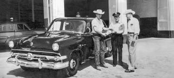 Tex Earnhardt (left) delivers a new 1952 Ford Mainline police car to the Chandler Police Department at the original Earnhardt Ford location in downtown Chandler. | Courtesy of Earnhardt Ford