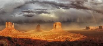 A stitched panorama of three photos made during an autumn storm at Monument Valley is by Enio Lanaro.