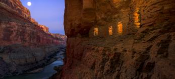 Light spills out of the Nankoweap granaries as the moon rises over the Colorado River at the Grand Canyon. | Adam Schallau