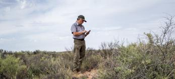 National Park Service Chief of Resources and Science Bill Parker logs artifacts that were strewn from vehicles on Historic Route 66 in Petrified Forest National Park during the 1950s. The paved road no longer exists. | Jeff Kida