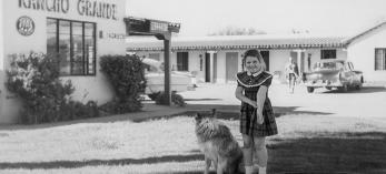 Eight-year-old Royce Kardinal, née Coxswell, and the family dog, Brenda, stand in front of the motel in Wickenburg where Royce grew up. | Courtesy Best Western Hotels
