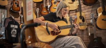 Gray Dog Music customer Julie Sullivan Brace plays one of the store’s available guitars. | Dawn Kish