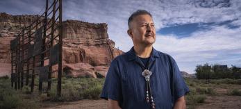 Master Diné silversmith Alvin Yellowhorse stands on the property of the former Ortega’s Indian Market in Lupton, with the Painted Cliffs behind him. | Joel Grimes