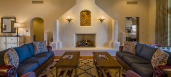 The spacious interior of a room at Ranchos de los Caballeros includes an adobe fireplace, wood beam ceilings and mirrored couches and coffee tables. | Laurence Parent