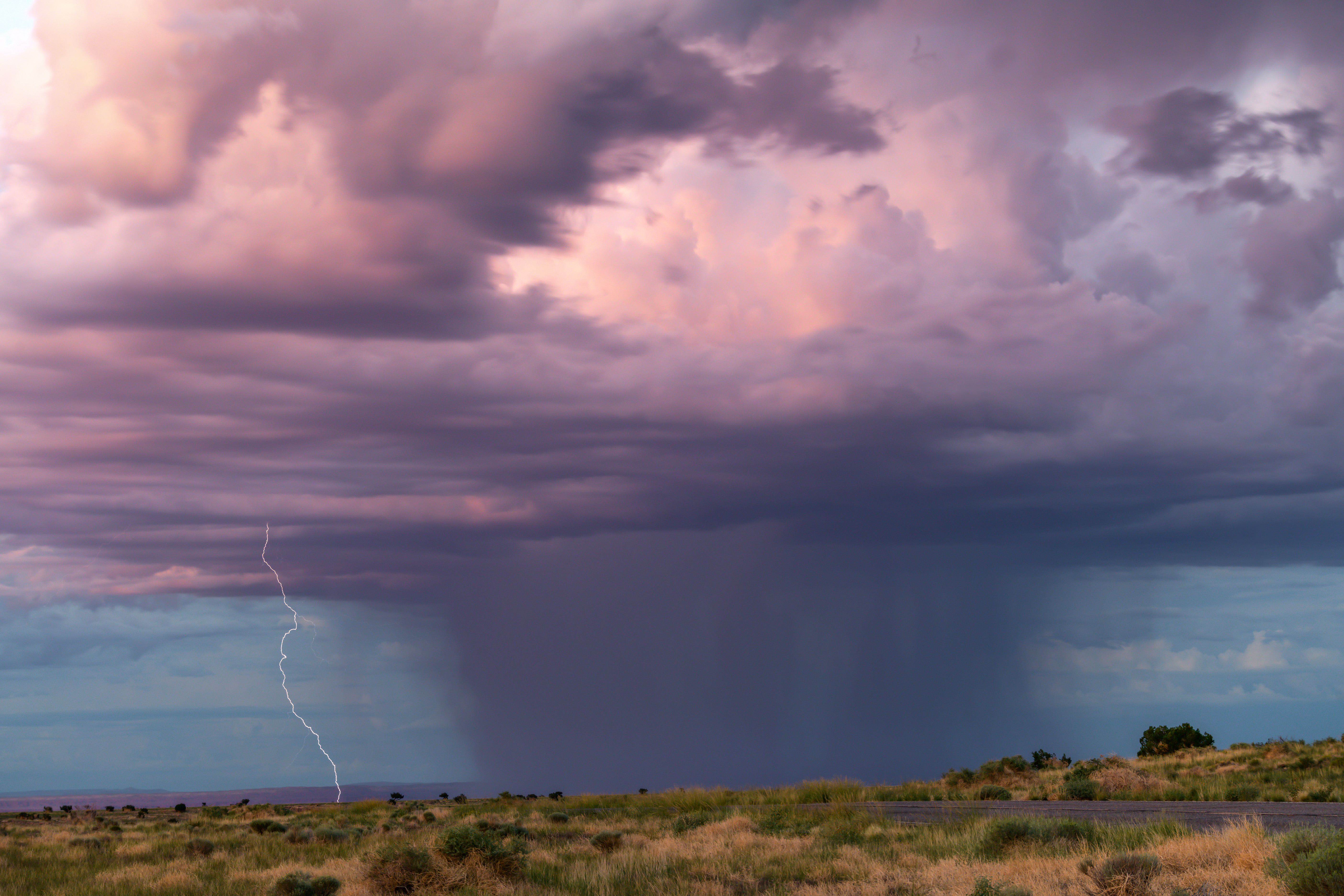 Photo by Lisa Manifold  |  A colorful Monsoon storm cell on the Wupatki National Monument grounds at sunset.