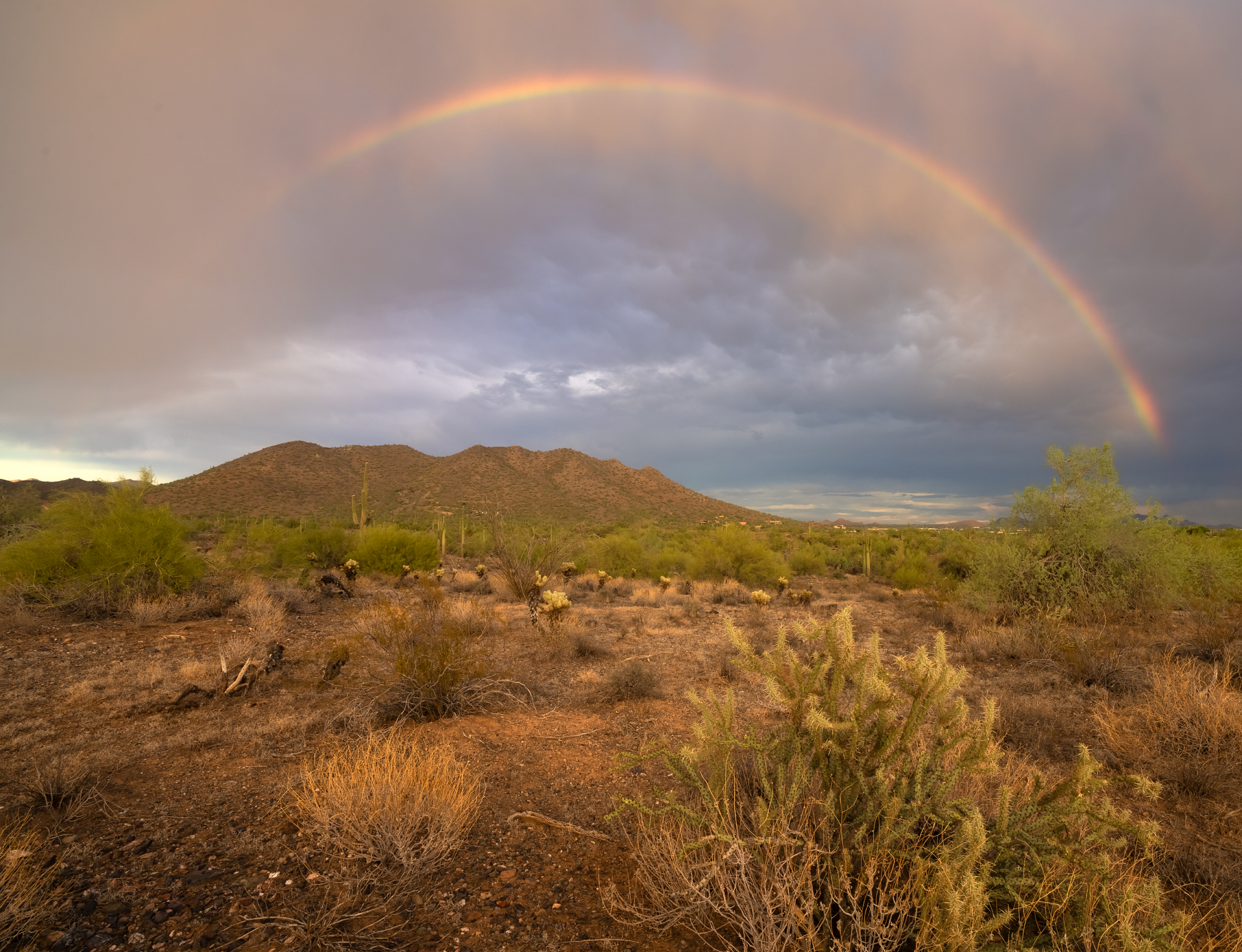 Photo by Ben Akers  |  Rainbow Over The Mountains near Cave Creek Regional Park in Cave Creek, Arizona After A Brief Monsoon Storm.