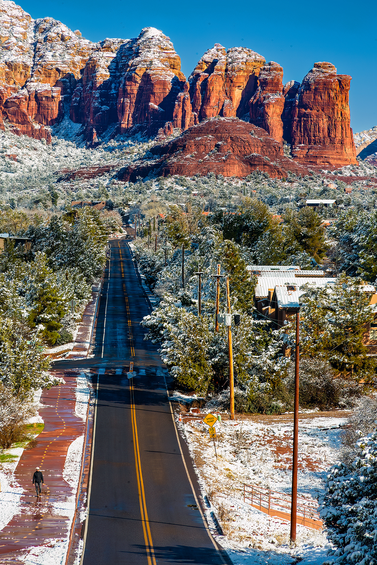 Photo by Susie Reed  |  I headed put early to capture the snow in Sedona before it melted. I love the leading line the road creates and the walking figure who gives a sense of scale. Coffee Pot Rock is in the upper right.