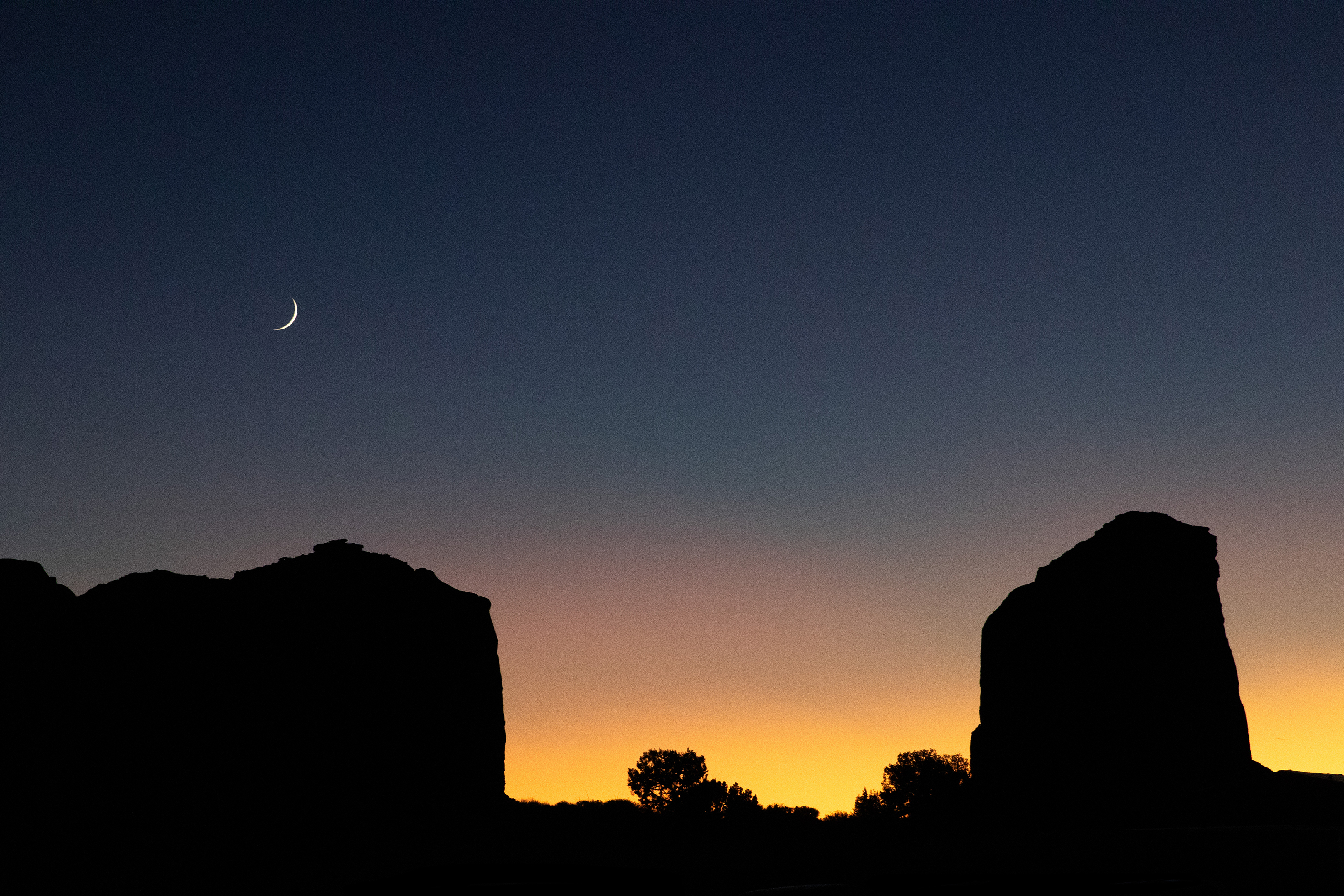 Photo by Valentina DeClaire  |  Taken just after sunset on Navajo Nation grounds in Monument Valley. I waited until the crescent moon was bright enough, while the colors of the sunset still sparkled on the horizon.